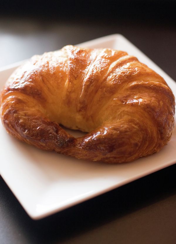 Cornetto dorato fatto in casa appena sfornato su piatto bianco